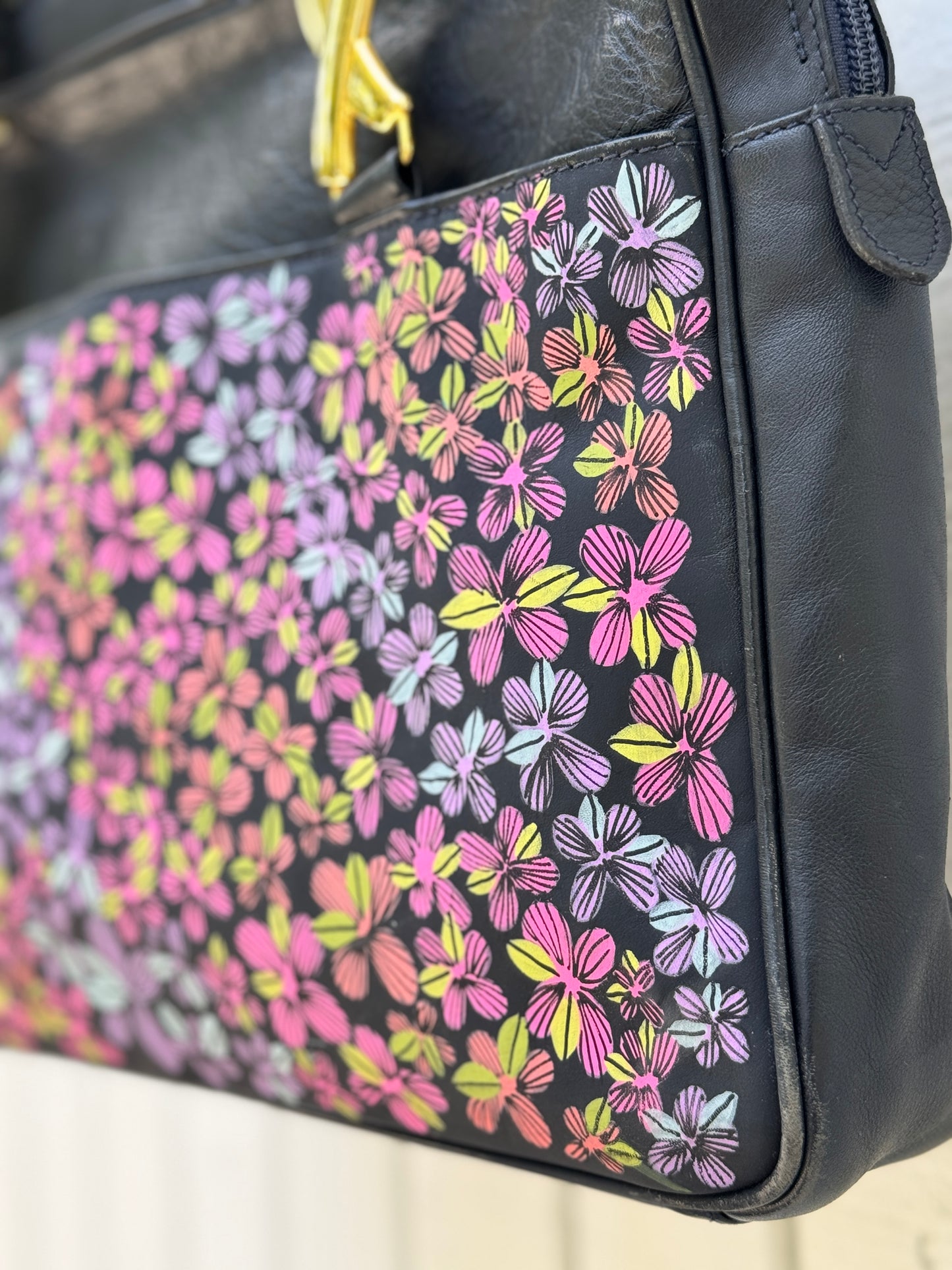 Navy leather bag by Paloma Picasso. This bag is from the 1990s. I painted multicolored flowers on it using Posca paint pens. The purse has shoulder straps with the iconic ‘X’ gold tone metal hardware linking them to the purse.

Opposite corner shot of light wear.